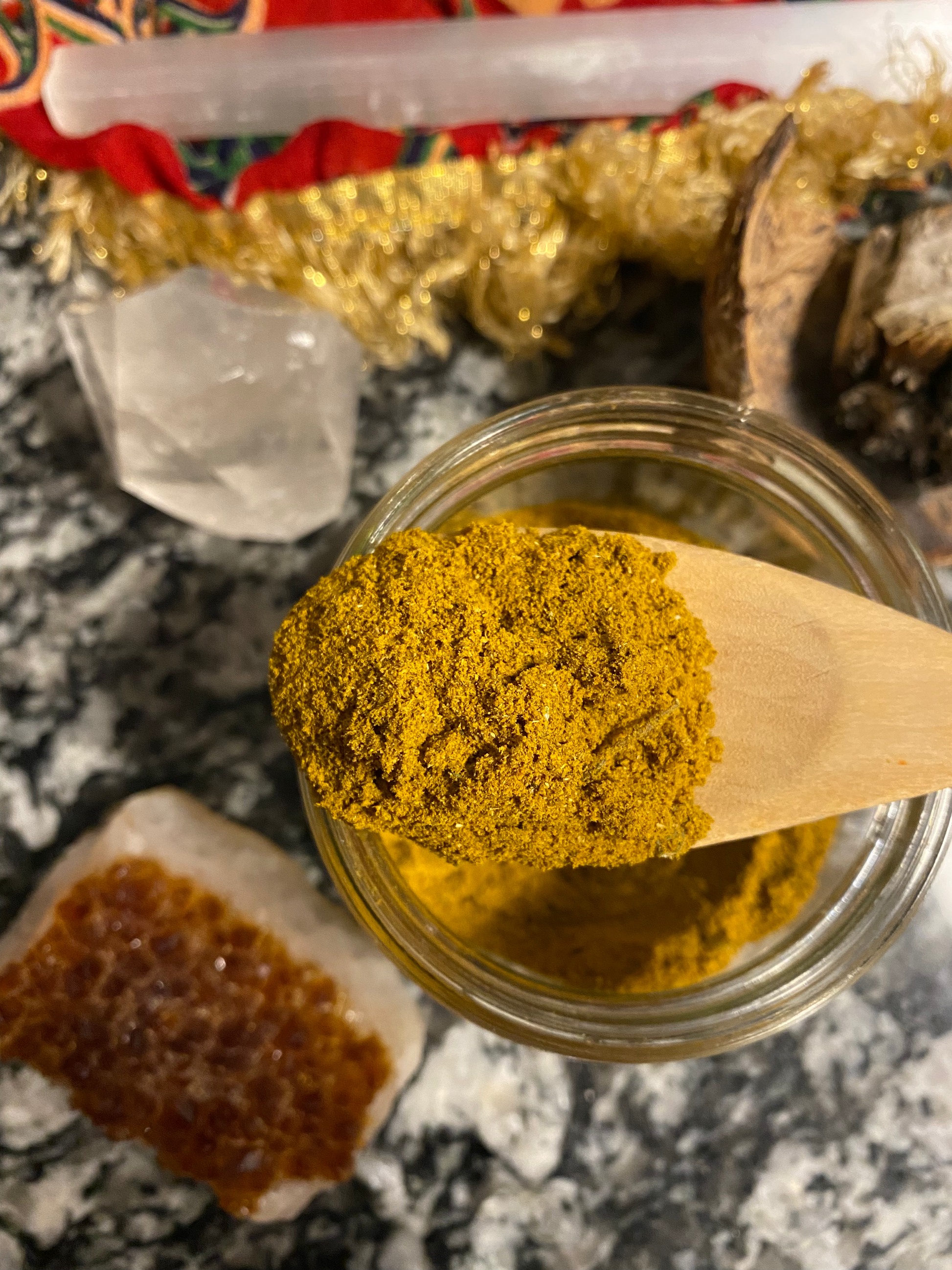 a seasoning and spice blend that is an orange-yellow color, in a glass bottle, with crystals all around the bottle.