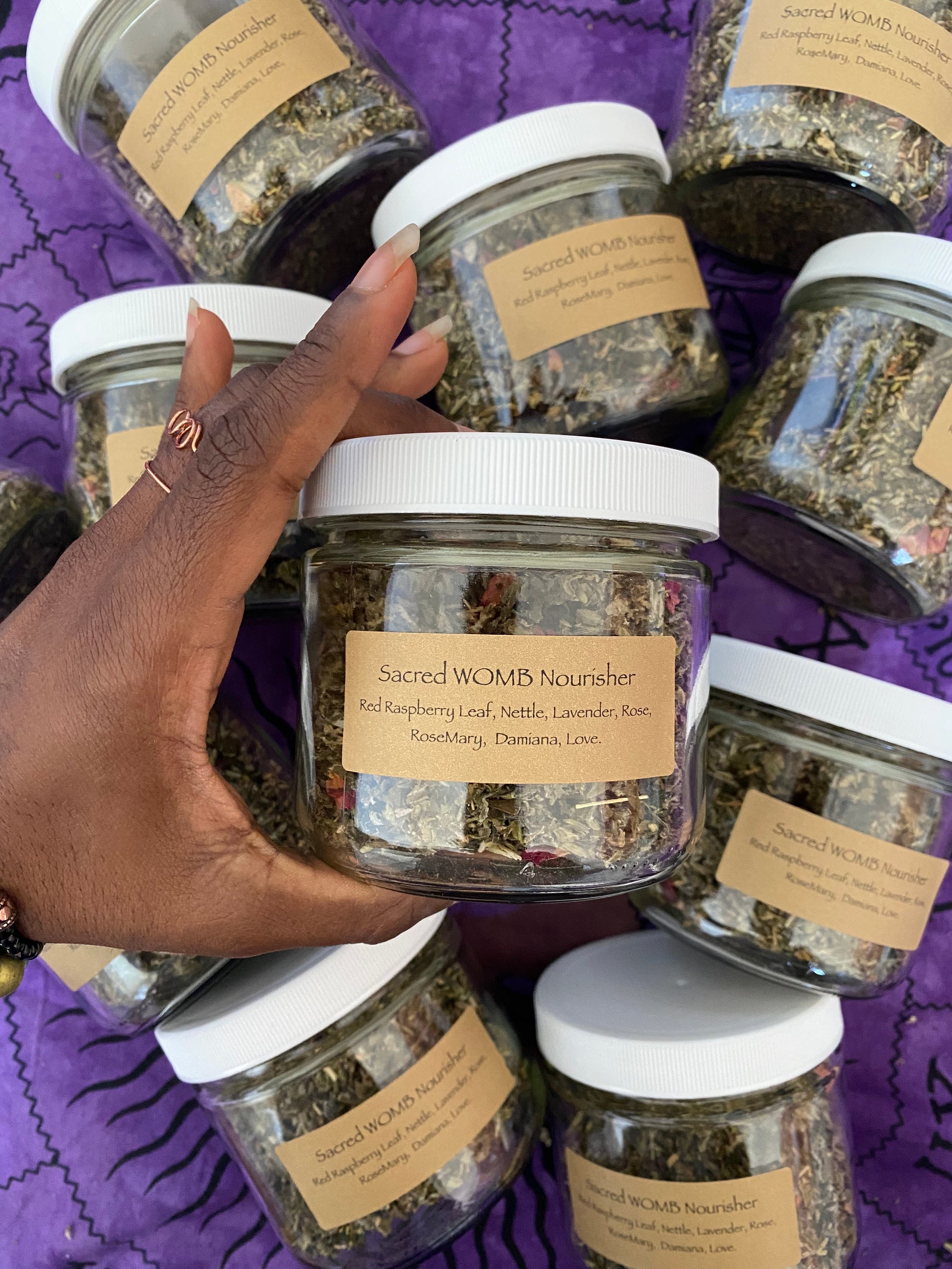 a natural, hand-made loose leaf herbal tea blend held in a glass bottle. these blends are potent and the colors of the herbs are red and green.